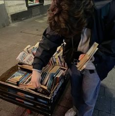 a person picking up books from a box