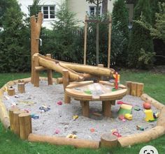 an outdoor play area with sand and toys