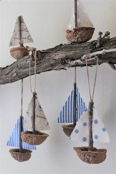 three sailboats are hanging from a tree branch