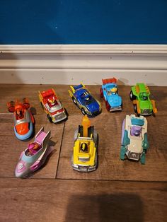 a group of toy cars sitting on top of a wooden floor next to each other