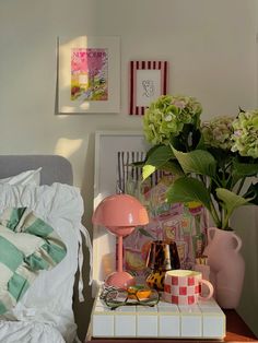 a bed with flowers and pictures on the wall next to it, along with other items