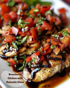 grilled chicken with balsamic glaze on a white plate topped with tomatoes and basil