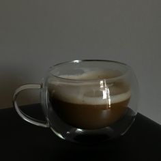 a glass cup filled with liquid sitting on top of a table