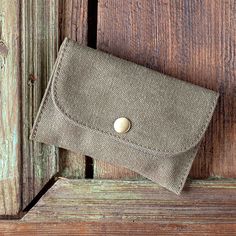 a small purse sitting on top of a wooden table next to a door with a button