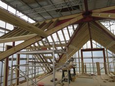 the inside of a building that is being constructed with wood and metal frameworks, including scaffolding