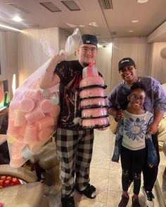 two men and a woman posing for a photo in front of some fake food items