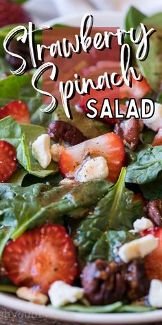 a salad with spinach, strawberries and feta cheese in it on a plate