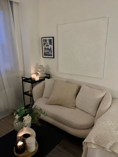 a living room with a couch, coffee table and pictures on the wall