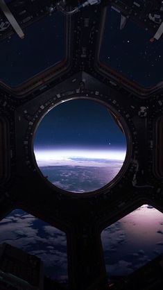 the view from inside an airplane looking out at the earth and stars in the sky