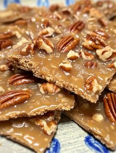 several pieces of pecan brittle on a blue and white plate