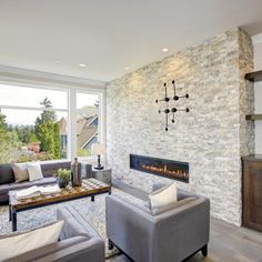 a living room filled with furniture and a fire place in front of a large window