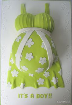 a green cake with white flowers on it and the words it's a boy