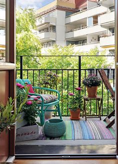 an open door to a balcony with potted plants on the floor and in front of it