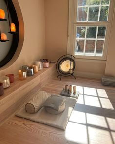 a room with candles on the floor and in front of a window