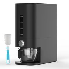 a black coffee maker next to a blue and white toothbrush on a white background