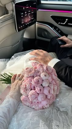 a bride and groom are sitting in the back seat of a car with flowers on it