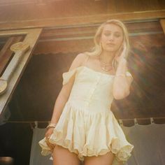 a woman in a short yellow dress talking on a cell phone