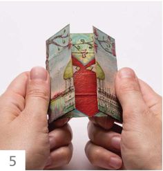 two hands holding up an origami piece