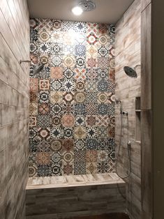 a tiled shower in a bathroom with wooden floors