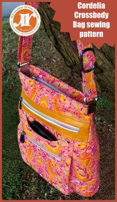 an orange and pink purse hanging from a tree