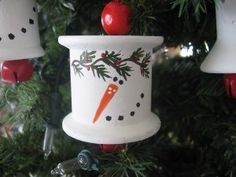 three ornaments hanging from a christmas tree in the shape of snowmen and carrots