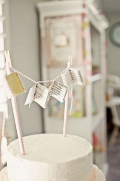 a white cake sitting on top of a table covered in frosting and bunting