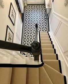 the stairs are lined with black and white tile