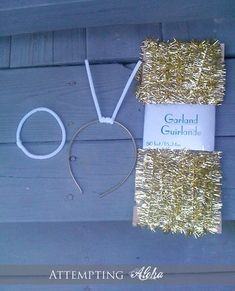 a pair of scissors and some tinsel next to a sign on a wooden wall