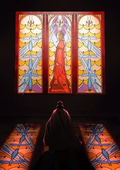 a woman standing in front of a stained glass window