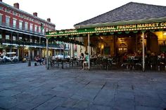 the outside of a french market with tables and chairs