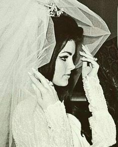 an old black and white photo of a woman in wedding dress with veil on her head