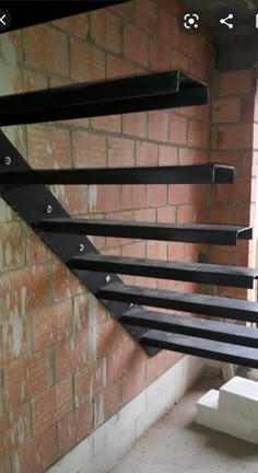 a black metal stair rail in front of a brick wall