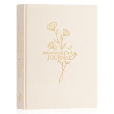 a white book with gold lettering and flowers