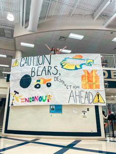 a woman standing on top of a sign in a gym