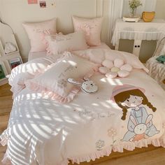 a bed with pink comforters and pillows on it