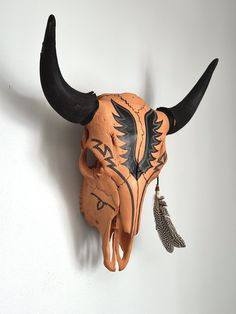 a bull's head is mounted to the wall with horns and feathers on it