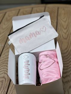 an open box with two items in it on a wooden table next to a bag