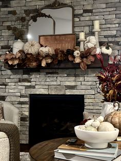 a living room filled with furniture and a fire place covered in pumpkins on top of a table