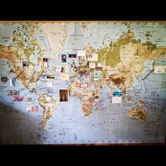 a world map with pins and magnets on it, in the middle of a room