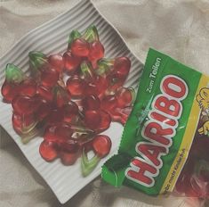 there is a bag of gummy bears next to a plate with candy on it