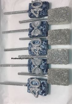 four blue and silver hair clips with sequins on them in a white box