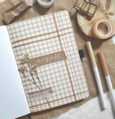 an open notebook sitting on top of a table next to a cup of coffee and other items