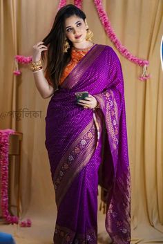 a woman in a purple sari posing for the camera