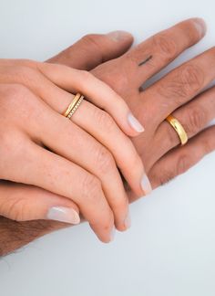 two people holding each other's hands with their wedding rings