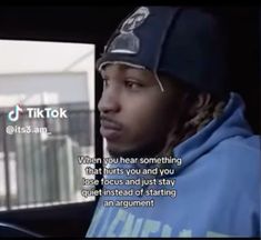 a young man in a blue hoodie sitting in the back seat of a car