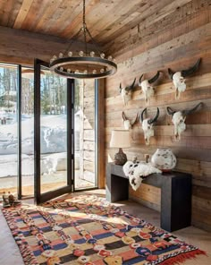 a room with deer heads mounted on the wall and a rug in front of it