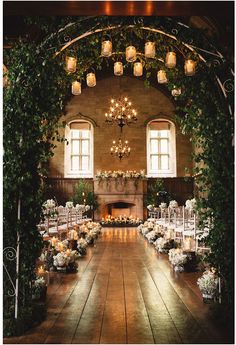 an indoor wedding venue with candles and greenery