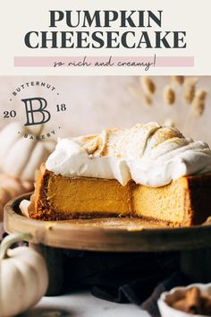 a pumpkin cheesecake with whipped cream on top is sitting on a wooden platter