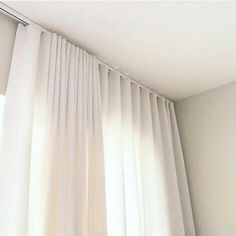 an open window with white drapes and curtains