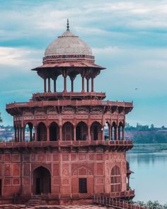 an old building with a dome on top next to the water